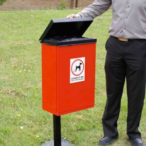 A man lifting up the lid to the red Front-Opening Dog Waste Bin.