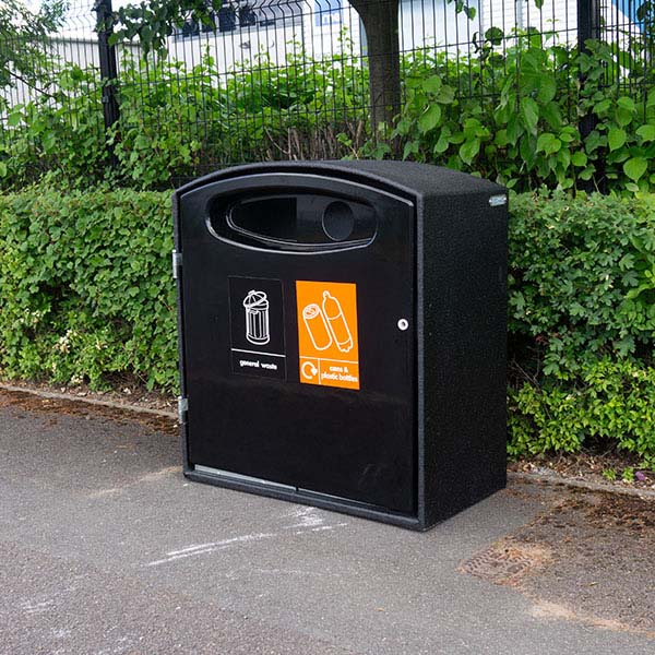 Mini Cyclo Double Litter Bin in all black in front of a bush.