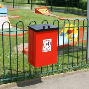 Red Dog Waste Bin with a lift-up lid fixed to a fence at a park.