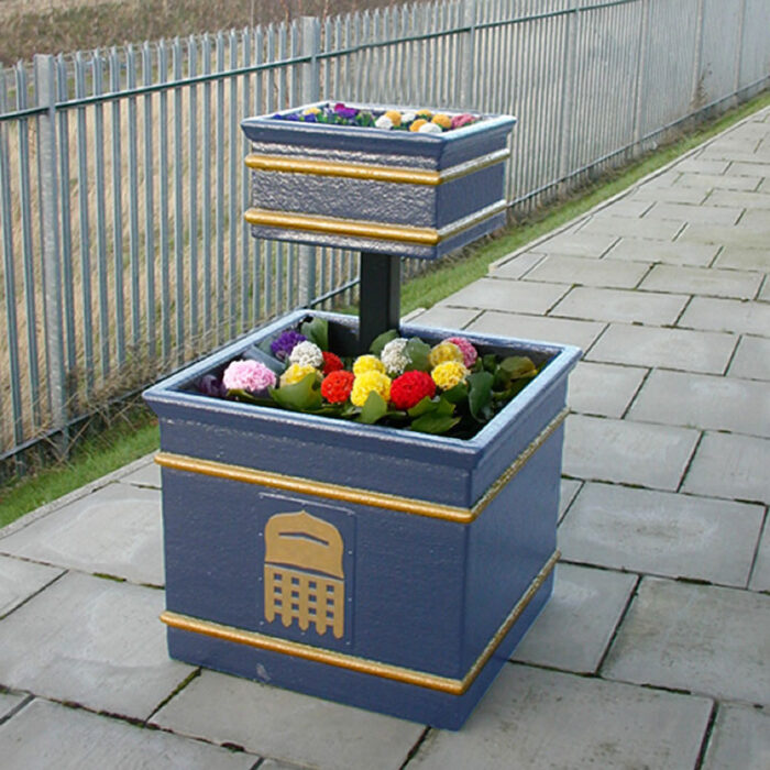 The VP/17 Two-Tier Flower Planter in dark blue with flowers inside.