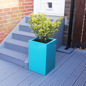 Turquoise Tall Flower Planter on grey garden decking.