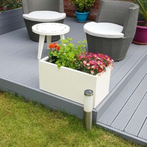 Off White Rectangular Flower Planter on grey garden decking with seats in the background.