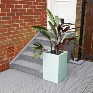 Pastel Green Tall Flower Planter on grey garden decking.