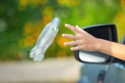 A plastic bottle being thrown from a car.
