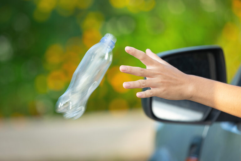 A plastic bottle being thrown from a car.