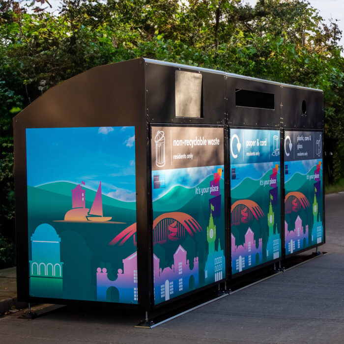 Wybone Apollo 1280l wheelie bin housing for Lanarkshire. Three waste recycling units with colorful artwork vinyls.