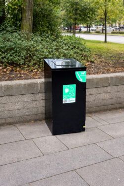 black bin with green label